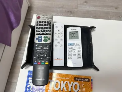 a group of remote controls sitting on top of a table at TRAVELERZ Tokyo Akasaka in Tokyo
