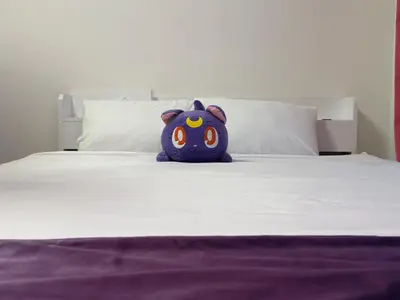 a purple teddy bear sitting on top of a bed at TRAVELERZ Tokyo Akasaka in Tokyo