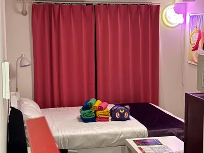 a room with a bed with red curtains at TRAVELERZ Tokyo Akasaka in Tokyo