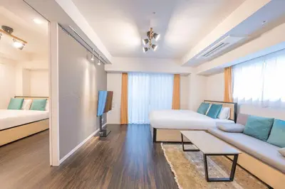 a room with two beds and a couch and a tv at \u30b0\u30e9\u30f3\u30c9\u30b3\u30f3\u30b7\u30a7\u30eb\u30b8\u30e5\u516d\u672c\u6728 in Tokyo