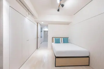 a small bedroom with a bed in a white wall at \u30b0\u30e9\u30f3\u30c9\u30b3\u30f3\u30b7\u30a7\u30eb\u30b8\u30e5\u516d\u672c\u6728 in Tokyo