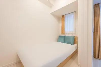 a small bedroom with a white bed and a window at \u30b0\u30e9\u30f3\u30c9\u30b3\u30f3\u30b7\u30a7\u30eb\u30b8\u30e5\u516d\u672c\u6728 in Tokyo