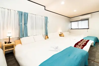 two beds in a room with blue curtains at 39, Kanegafuchi 2, Entire house for rent, \u9418\u30f6\u6df52 in Tokyo