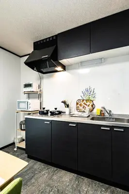 a kitchen with black cabinets and a sink at 39, Kanegafuchi 2, Entire house for rent, \u9418\u30f6\u6df52 in Tokyo