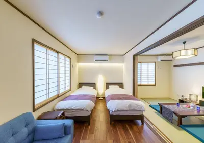 a room with two beds and a blue couch at Ydoya Fukuro - Vacation STAY 52727v in Tokyo