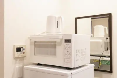 a microwave sitting on top of a toilet at SLEEPLAB \u6d45\u8349 -Asakusa- in Tokyo