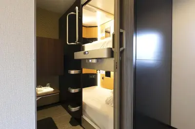 a small room with a bed and a sink at SLEEPLAB \u6d45\u8349 -Asakusa- in Tokyo