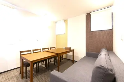 a dining room with a table and a couch at SLEEPLAB \u6d45\u8349 -Asakusa- in Tokyo