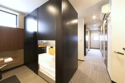 a corridor of a hotel room with a bed at SLEEPLAB \u6d45\u8349 -Asakusa- in Tokyo