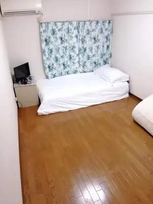 a small bedroom with a bed and a wooden floor at Tokyo downtown in Tokyo