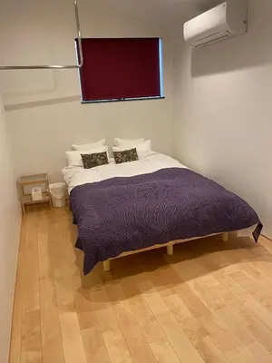 a bedroom with a bed with a purple blanket at Spacious Home in Ebisu Heart of Tokyo in Tokyo