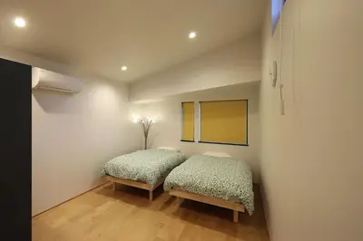 a bedroom with two beds and a mirror at Spacious Home in Ebisu Heart of Tokyo in Tokyo