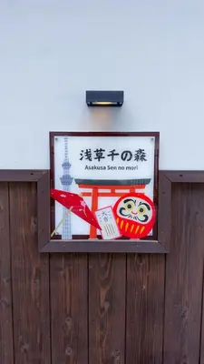 a sign on a wooden fence with a sign at \u6771\u4eac\u96f7\u9580\u30fc\u5343\u306e\u68eeAsakusa in Tokyo