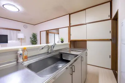 a kitchen with a stainless steel sink and white cabinets at Higashi Komagata Building 2F3F HK23 in Tokyo