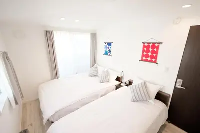 two beds in a room with a window at Mi-Villa Kami-Ikebukuro in Tokyo