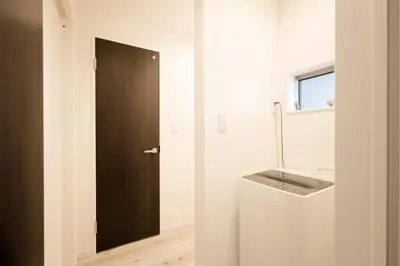 a bathroom with a black door and a sink at Mi-Villa Kami-Ikebukuro in Tokyo