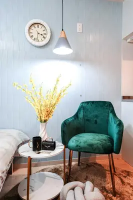a living room with a green chair and a clock at B21\u6c60\u888b\u4e2d\u5fc3 \u4ea4\u901a\u4fbf\u5229 \u8f66\u7ad93\u5206\u949f \u6700\u59274\u4eba Ikebukuro center 3 mins to ST Max 4P \u76f4\u8fbe\u65b0\u5bbf \u6d89\u8c37 \u8868\u53c2\u9053 \u6c60\u888b \u4e0a\u91ce \u4ee3\u4ee3\u6728 \u94f6\u5ea7 \u539f\u5bbf in Tokyo