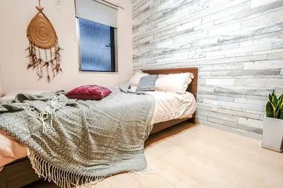 a bedroom with a bed and a brick wall at B12\u6c60\u888b\u4e2d\u5fc3 \u4e09\u5ba4 \u4ea4\u901a\u4fbf\u5229 \u8f66\u7ad93\u5206\u949f 3 rooms Ikebukuro center 3 mins to ST Max 8P \u76f4\u8fbe\u65b0\u5bbf \u6d89\u8c37 \u8868\u53c2\u9053 \u6c60\u888b \u4e0a\u91ce \u4ee3\u4ee3\u6728 \u94f6\u5ea7 \u539f\u5bbf in Tokyo
