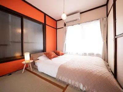 a bedroom with orange walls and a bed and a window at 6min to subway, Skytree,Ueno,Asakusa within 20min in Tokyo