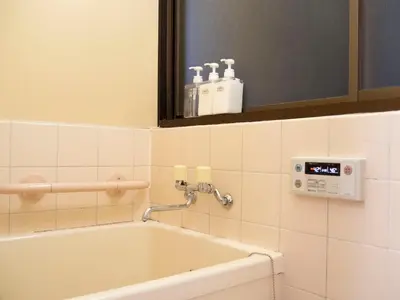 a bath tub in a bathroom with a clock on the wall at 6min to subway, Skytree,Ueno,Asakusa within 20min in Tokyo