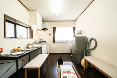 a kitchen with a refrigerator and a table and chairs at 44, Sumiyoshi 2, Entire house for rent, \u4f4f\u54092 in Tokyo