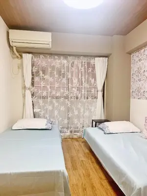 two beds in a room with a window at Shinjuku Kabukicho#high speed WIFI#3Minutes tosubway#\u65b0\u5bbf\u4e2d\u5fc3\u5730\u5e26\u8457\u540d\u6b4c\u821e\u4f0e\u753a \u8f66\u7ad9\u6b65\u884c3\u5206#24\u5c0f\u65f6\u4fdd\u5b89Shinjuku429 in Tokyo