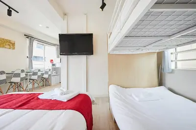 a bedroom with two beds and a flat screen tv at Shateray Yoyogi 501 SY51 in Tokyo
