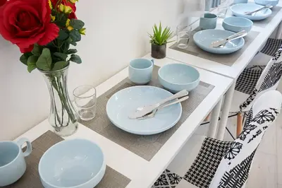 a table with blue plates and a vase with a red rose at Shateray Yoyogi 501 SY51 in Tokyo