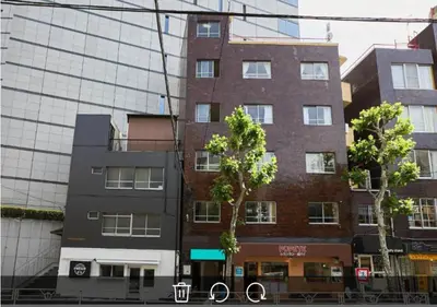 a tall brick building in front of a glass building at Shateray Yoyogi 501 SY51 in Tokyo