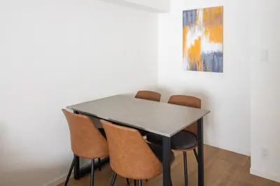a table and chairs in a room with a painting at \u30d7\u30ec\u30fc\u30eb \u30c9\u30a5\u30fc\u30af\u83ca\u5ddd in Tokyo