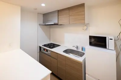 a small kitchen with a sink and a microwave at \u30d7\u30ec\u30fc\u30eb \u30c9\u30a5\u30fc\u30af\u83ca\u5ddd in Tokyo
