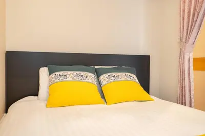 a bed with two yellow pillows on top of it at One Bedroom Family Suite Close Ikebukuro Max 4ppl in Tokyo
