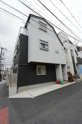 a black and white house on the side of a street at 100 INN Standard in Tokyo