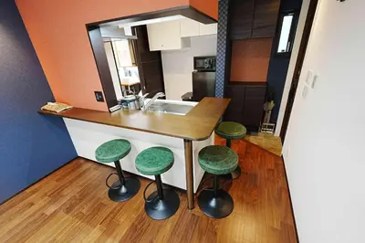 a kitchen with a counter with stools and a sink at 100 INN Standard in Tokyo