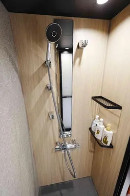 a shower in a bathroom with a mirror at 100 INN Standard in Tokyo