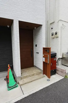 a garage with a wooden door and a green cone at 100 INN Standard in Tokyo