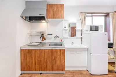 a kitchen with a white refrigerator and a sink at W Hostel in Tokyo