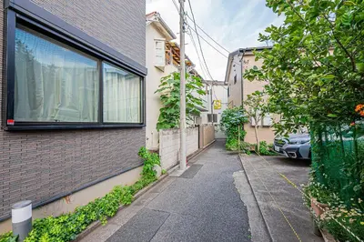 an alley with a car parked next to a building at W Hostel in Tokyo