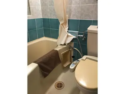 a bathroom with a toilet and a tub with a shower curtain at Business Hotel Crescent - Vacation STAY 49310v in Tokyo