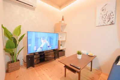 a living room with a flat screen tv and a coffee table at OHAYO Hotel \u5927\u68ee\u897f in Tokyo