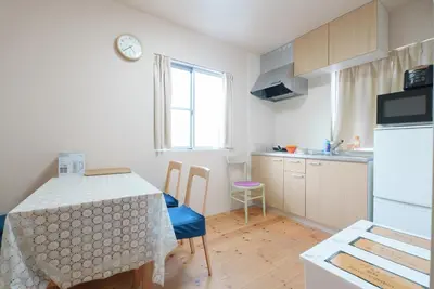 a kitchen with a table and a kitchen with a table and chairs at OHAYO Hotel \u5927\u68ee\u897f in Tokyo