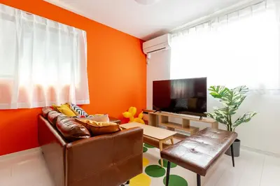 a living room with orange walls and a brown leather couch at Good access 3LDK 15 people! Spacious room in Tokyo