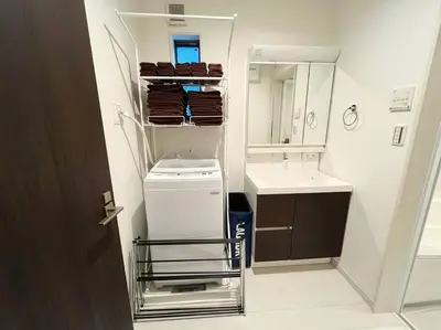 a bathroom with a sink and a washer and dryer at Good access 3LDK 15 people! Spacious room in Tokyo