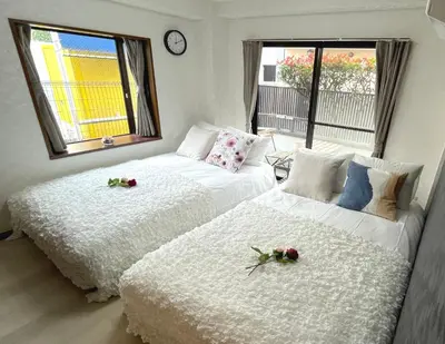 two beds in a room with flowers on them at #1 \u65b0\u5bbf\u307e\u30672\u5206! \u6e05\u6f54\u3067\u5b89\u5168\u306a\u90e8\u5c4b! WiFi\u7121\u6599! in Tokyo