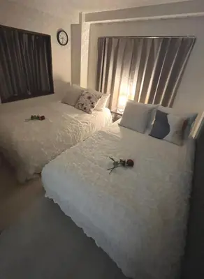 two beds with roses on them in a bedroom at #1 \u65b0\u5bbf\u307e\u30672\u5206! \u6e05\u6f54\u3067\u5b89\u5168\u306a\u90e8\u5c4b! WiFi\u7121\u6599! in Tokyo