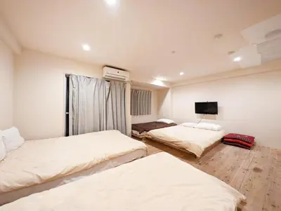 a bedroom with two beds and a tv on the wall at \u30db\u30c6\u30eb\u9685\u7530\u5ddd in Tokyo