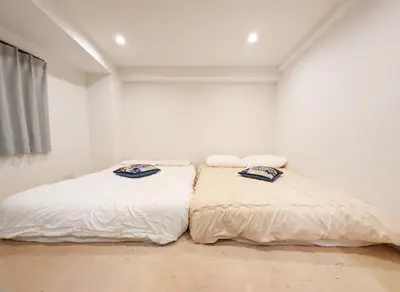 two beds in a room with white walls at \u30db\u30c6\u30eb\u9685\u7530\u5ddd in Tokyo
