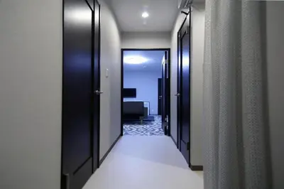 a hallway with black doors and a hallway with a room at KINO\u6d45\u8349b\u68df in Tokyo
