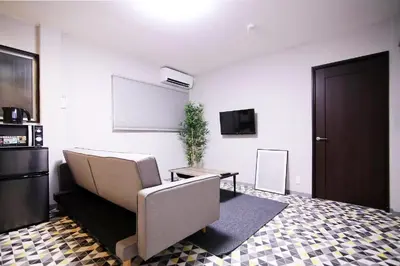 a living room with a couch and a white wall at KINO\u6d45\u8349b\u68df in Tokyo