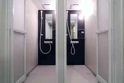 a row of stalls in a bathroom with mirrors at KINO\u6d45\u8349b\u68df in Tokyo